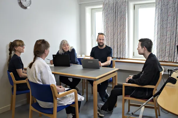 Sundhedsprofessionelle fra Specialhospitalet har en samtale med en patient