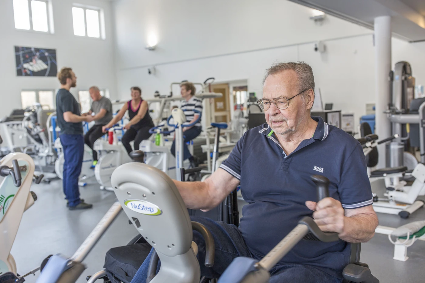 Mand træner ved maskine i motionscenter
